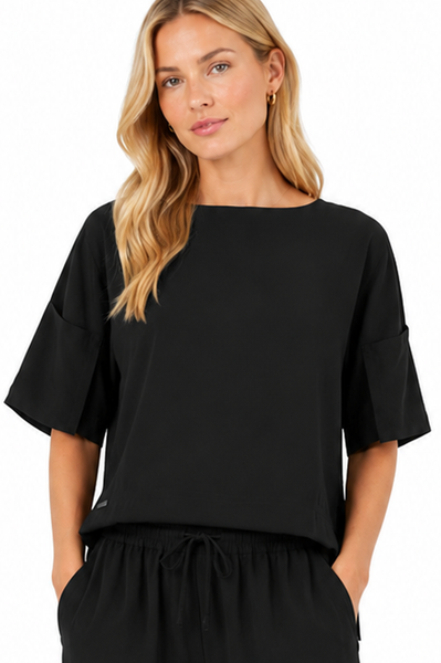 Model wearing the BLACKPANTS Mykonos Boat Neck Top in black with a relaxed boat neckline, wide sleeves and contemporary boxy silhouette.