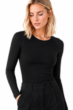 Close-up of model wearing the BLACKPANTS Essential Layering Top in black, featuring a boat neckline, long sleeves and body-skimming stretch fit.