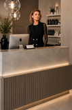 Salon professional wearing the BLACKPANTS Boston Vest at reception, showcasing the tailored silhouette and double-breasted button detailing.